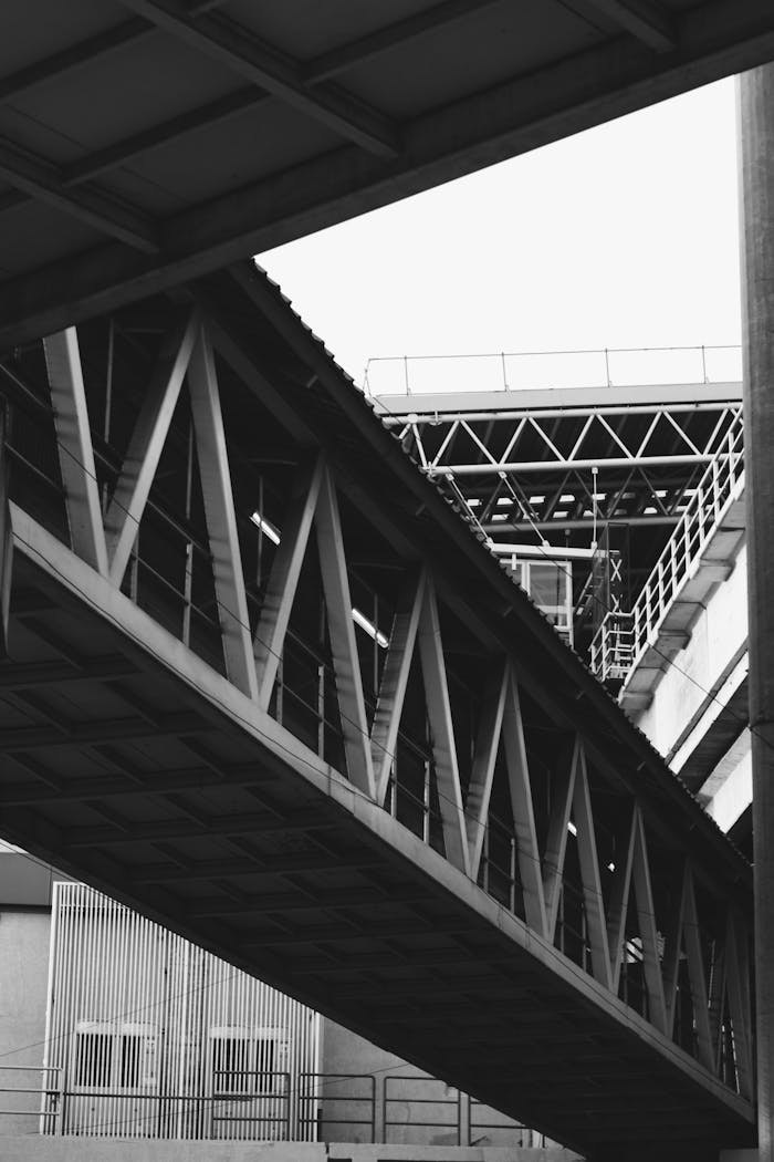 Monochrome photo of an industrial steel bridge showing structural design.